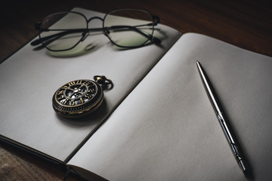 Antique pocket watch resting on an open handwritten notebook